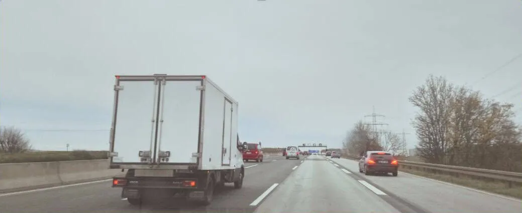 Autobahn mit LKW und Autos.