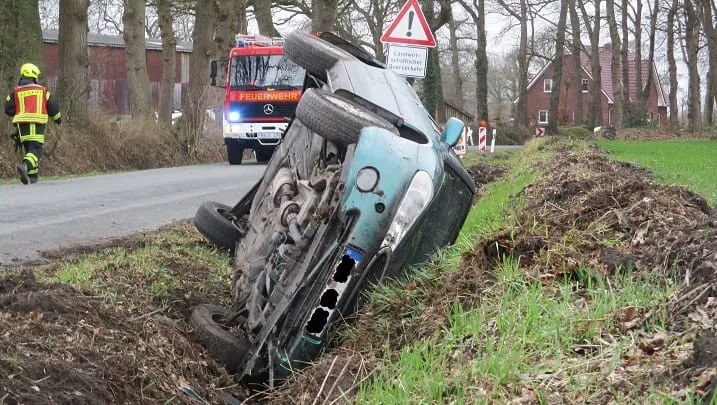 Auto im Graben nach Unfall, Feuerwehr vor Ort.
