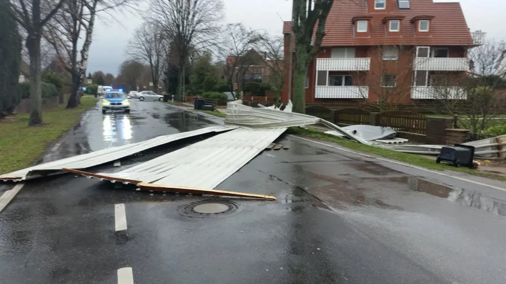 Sturmschaden blockiert Straße, Polizei vor Ort.