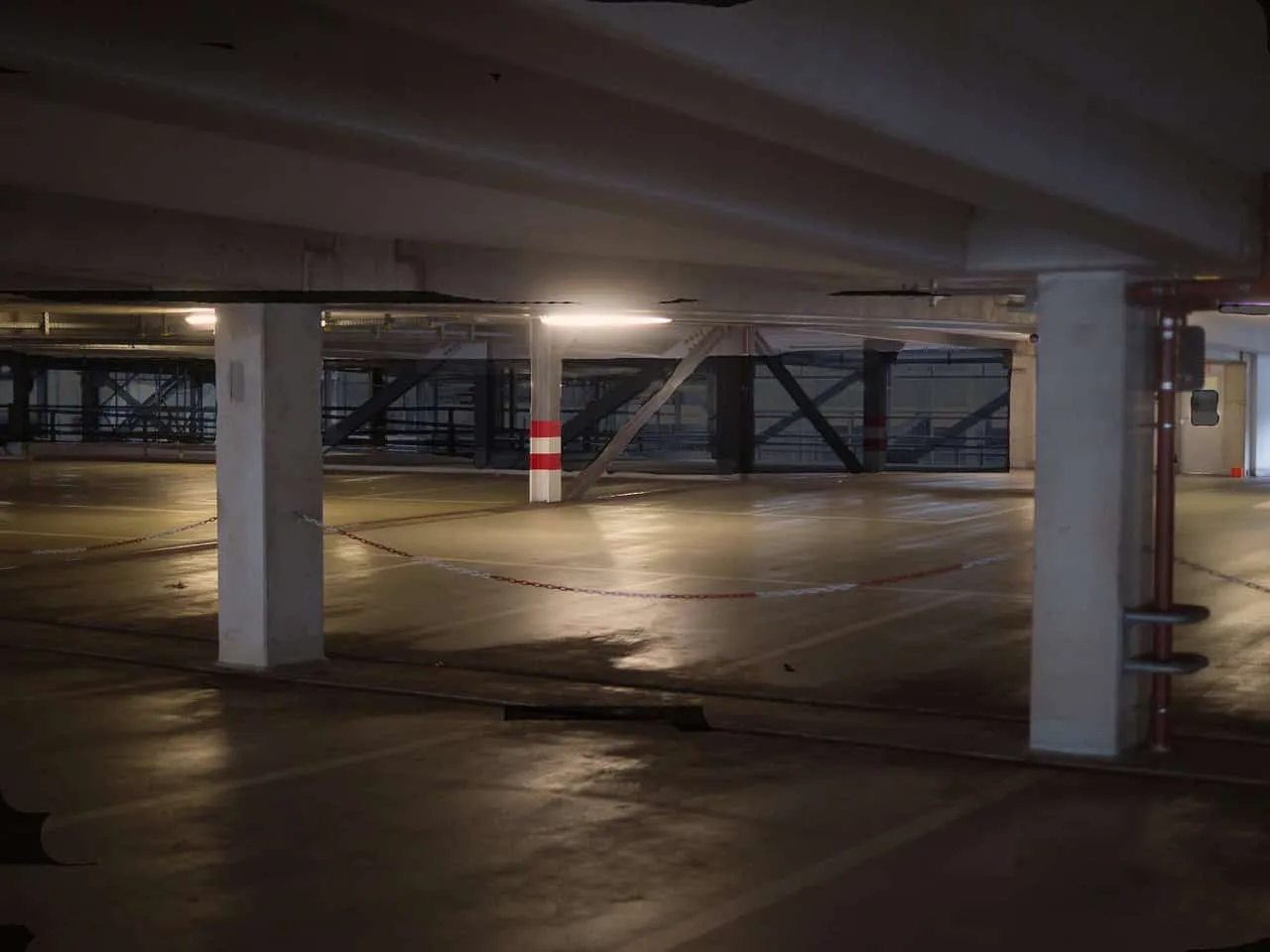 Leeres Parkhaus mit Beleuchtung und Säulen.